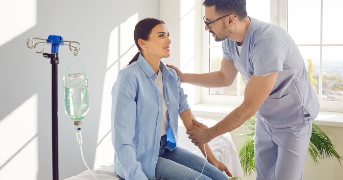 Healthcare provider administering IV therapy to seated woman in Wake Forest, NC